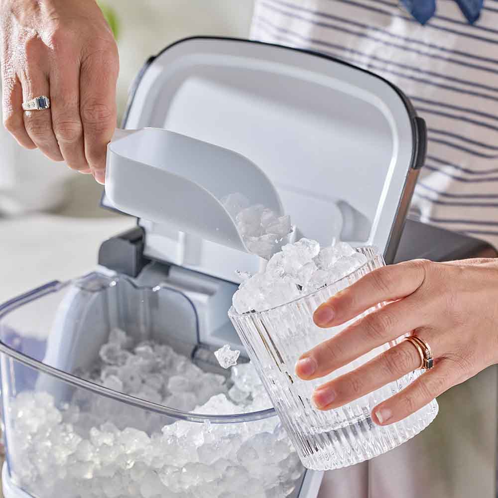 woman scooping ice into a glass from an ice maker