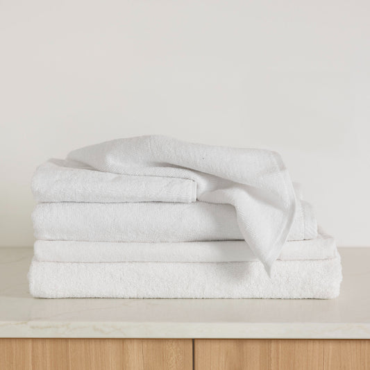 The white Bambury Chateau range folded ready for use, including the bath sheet, bath towel, bath mat, and face washer.