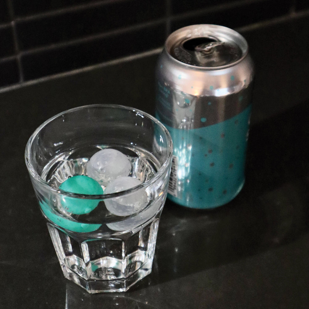 Golf ball ice cube moulds in the glass showing the size and shape of the product.