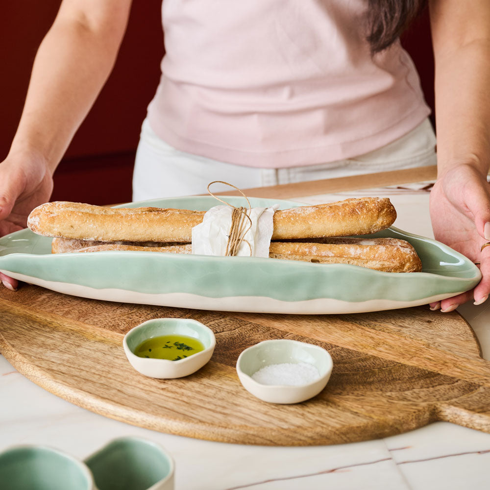 The Ecology Selvedge set of 2 dip bowls displayed on a bread board with olive oil and salt.