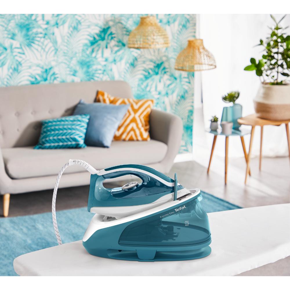 blue steam iron on an ironing board in the loungeroom - House
