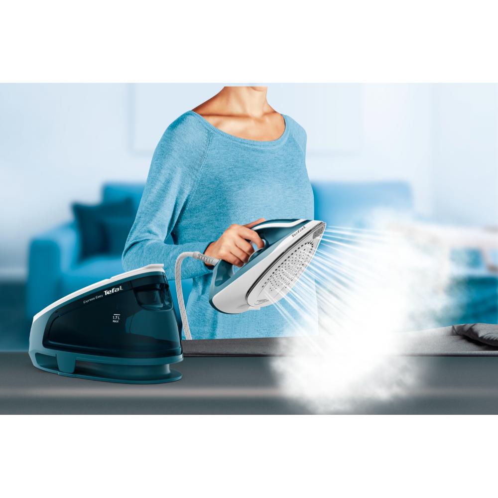 woman releasing steam from steam iron - House