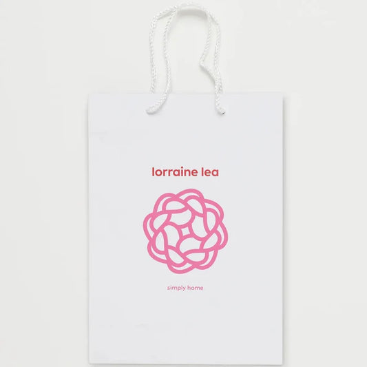 White product packaging with pink logo and text on a white background