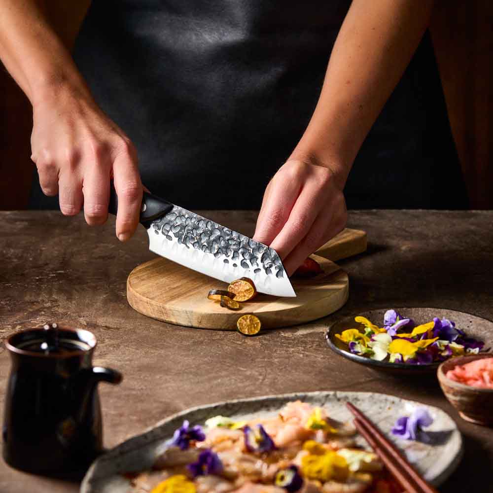 Woman slicing eggplant with Baccarat KUROI KIBA Santoku Knife 14cm at House