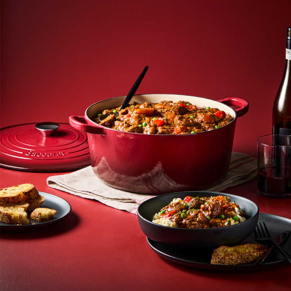 beef casserole in red dutch french oven with bread and wine - House