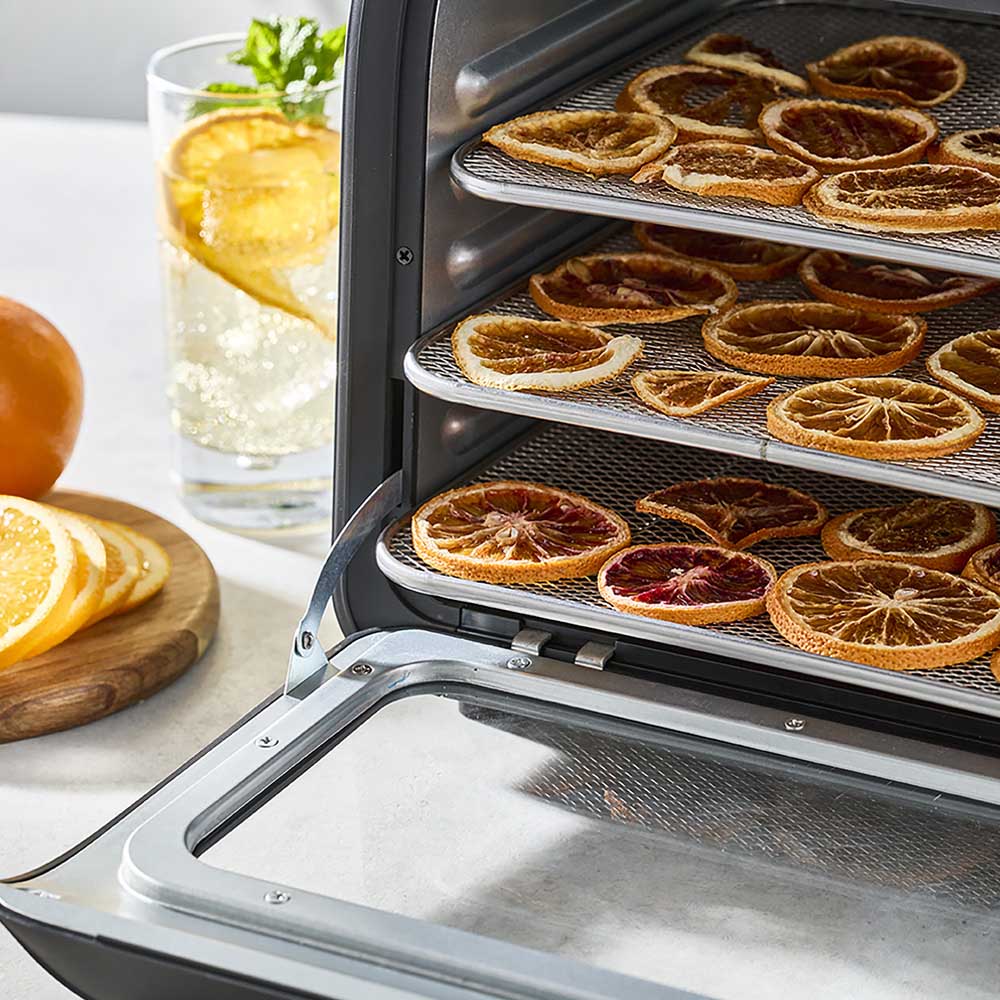 black dehydrator wth racks of orange slices