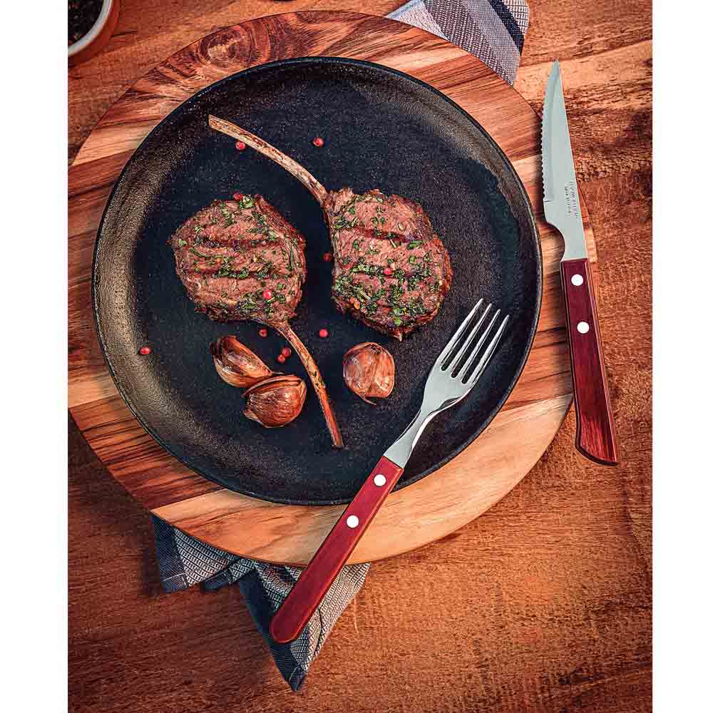 steak knife set with plate of cutlets on wooden table - House