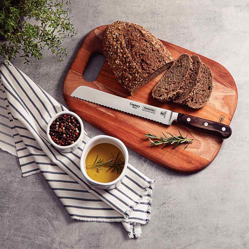 loaf of bread on a chopping board with slices of bread and a bread knife - House