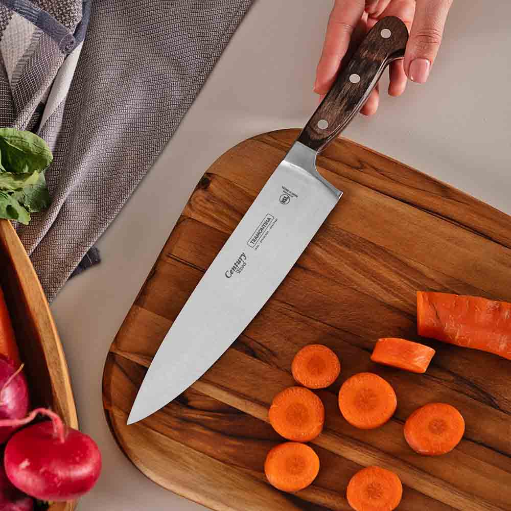 woman chopping carrot at kitchen counter with chef knife - House