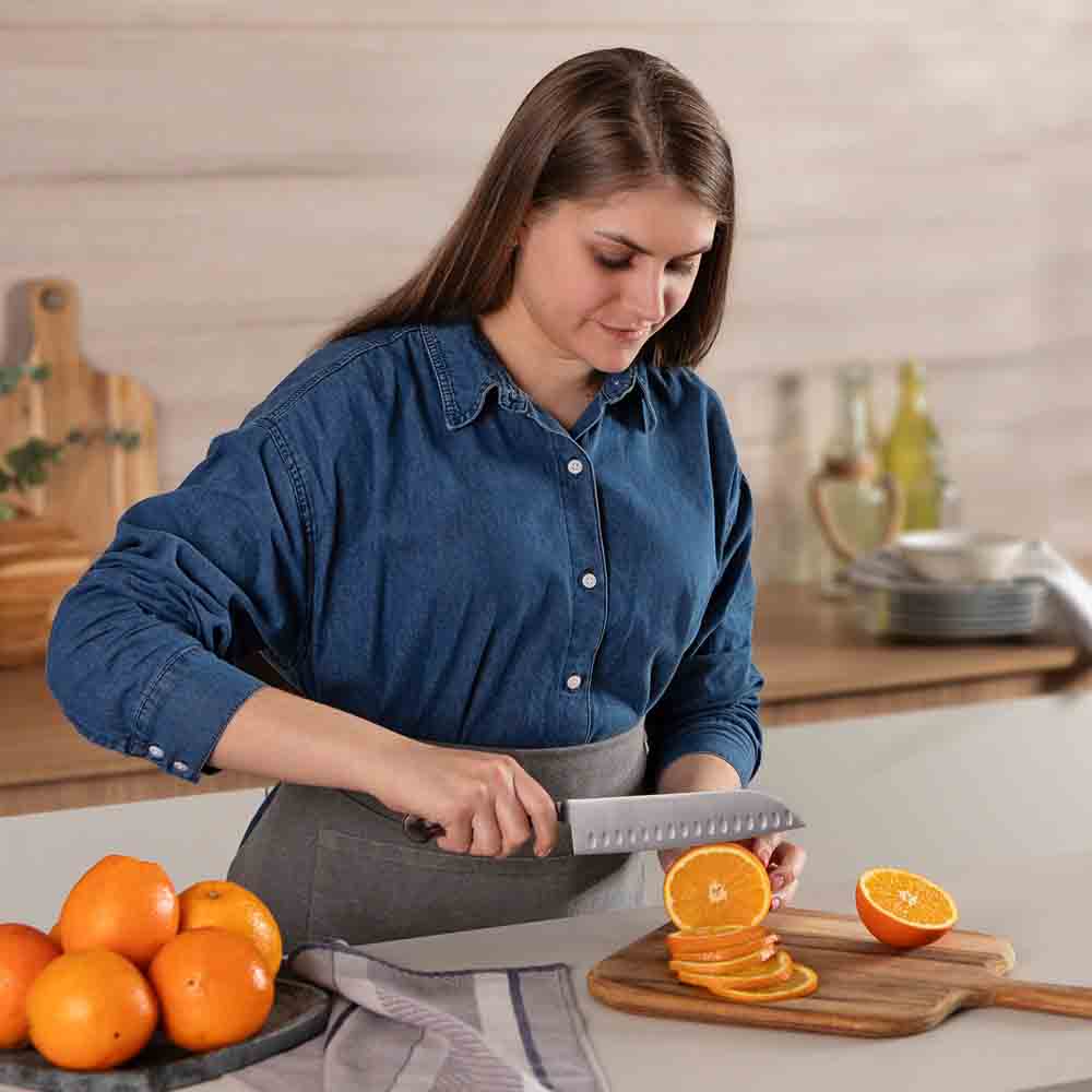 Woman slicing an orange with Santoku Knife 7 Inch - House