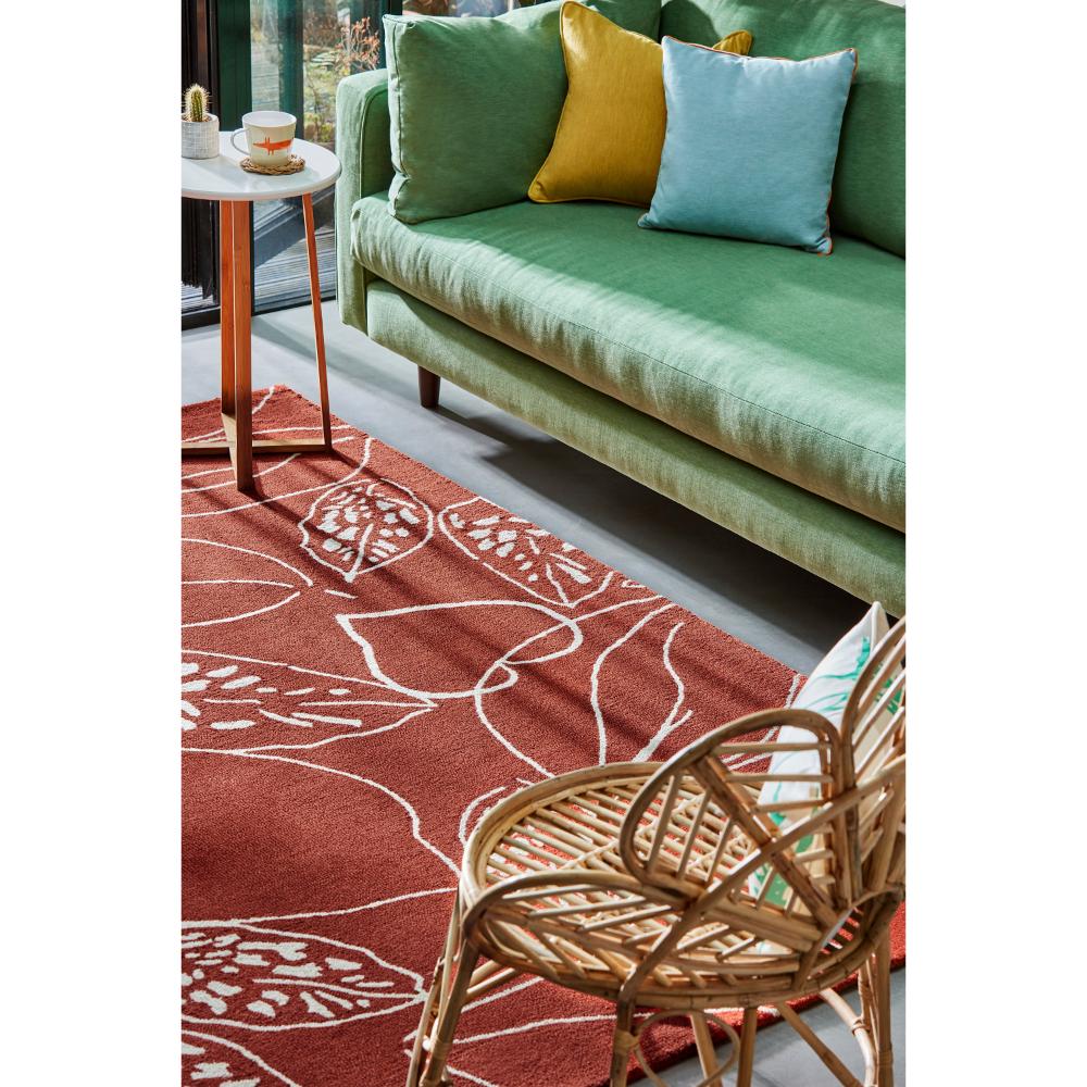 red leaf wool rug with green couch in loungeroom - House