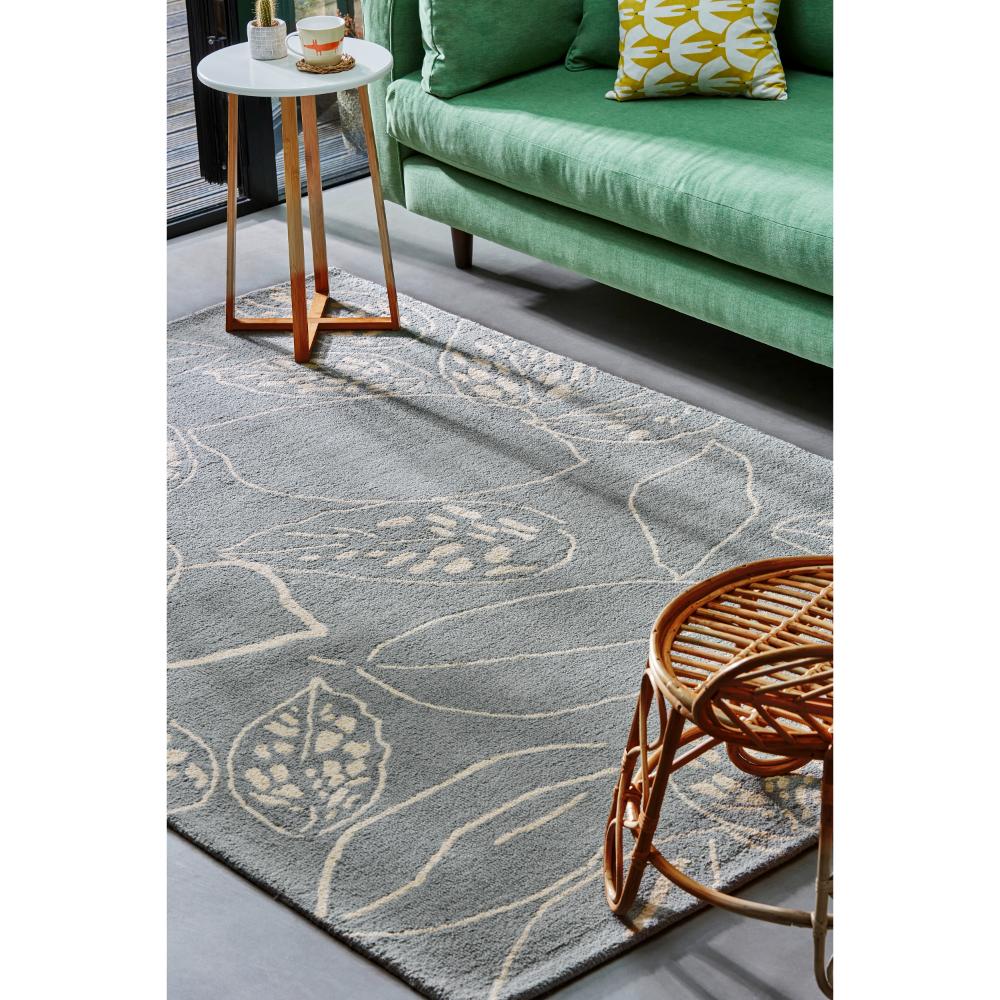 blue leaf wool rug with green couch in loungeroom - House