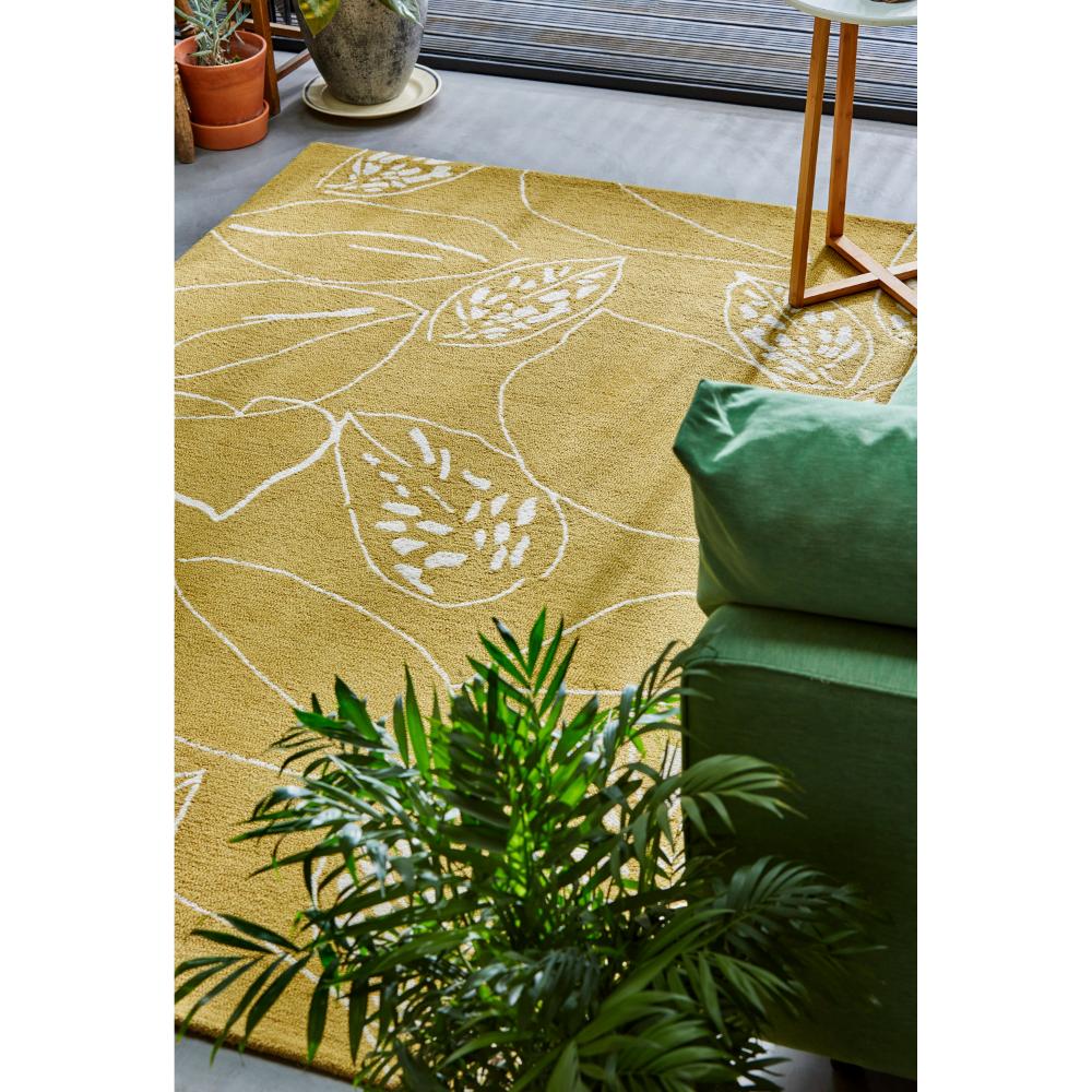 yellow leaf wool rug with green couch in loungeroom - House