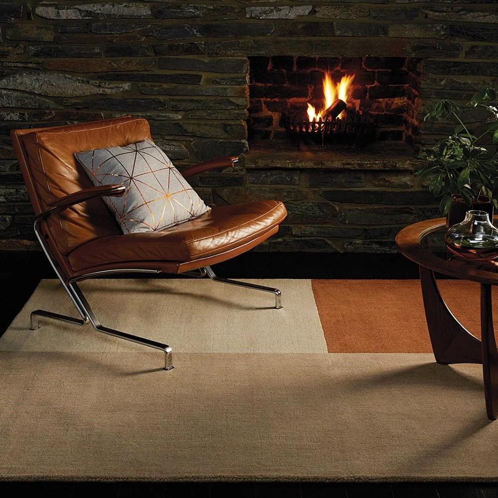 brown block design wool rug in front of a fireplace