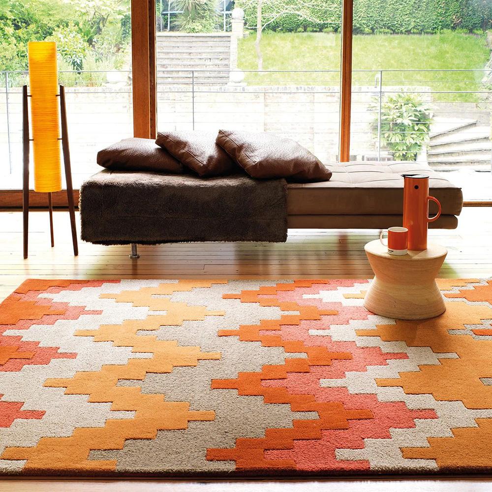 orange and red zig zag design wool rug in a sunroom
