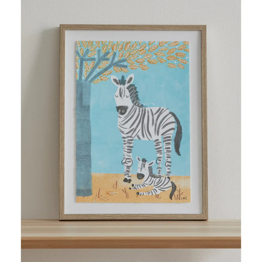 Framed artwork of a zebra and baby zebra under a tree on a wall.